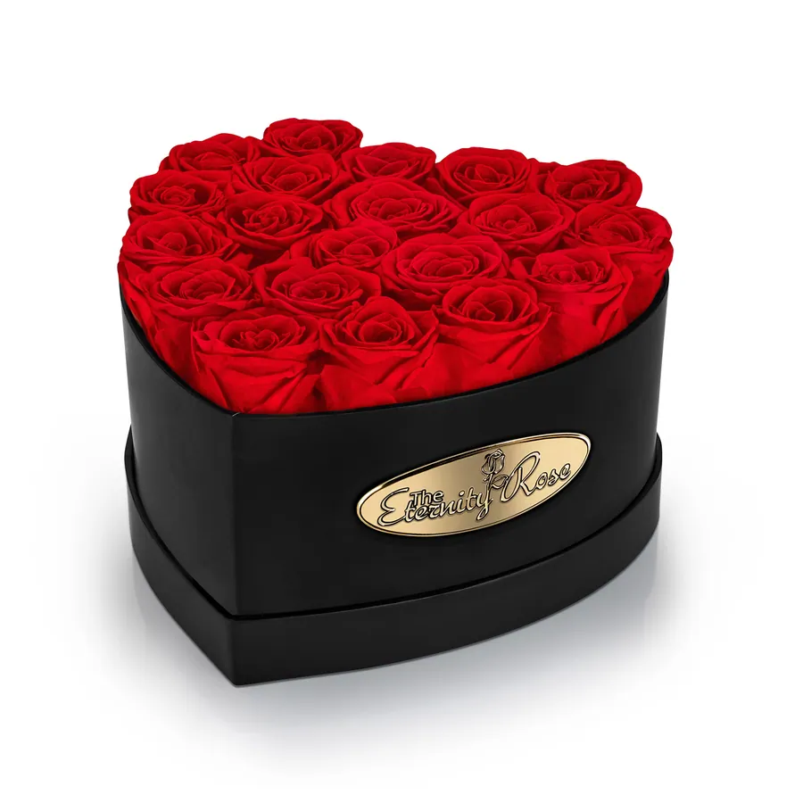 Red preserved roses arranged in a black heart-shaped presentation box